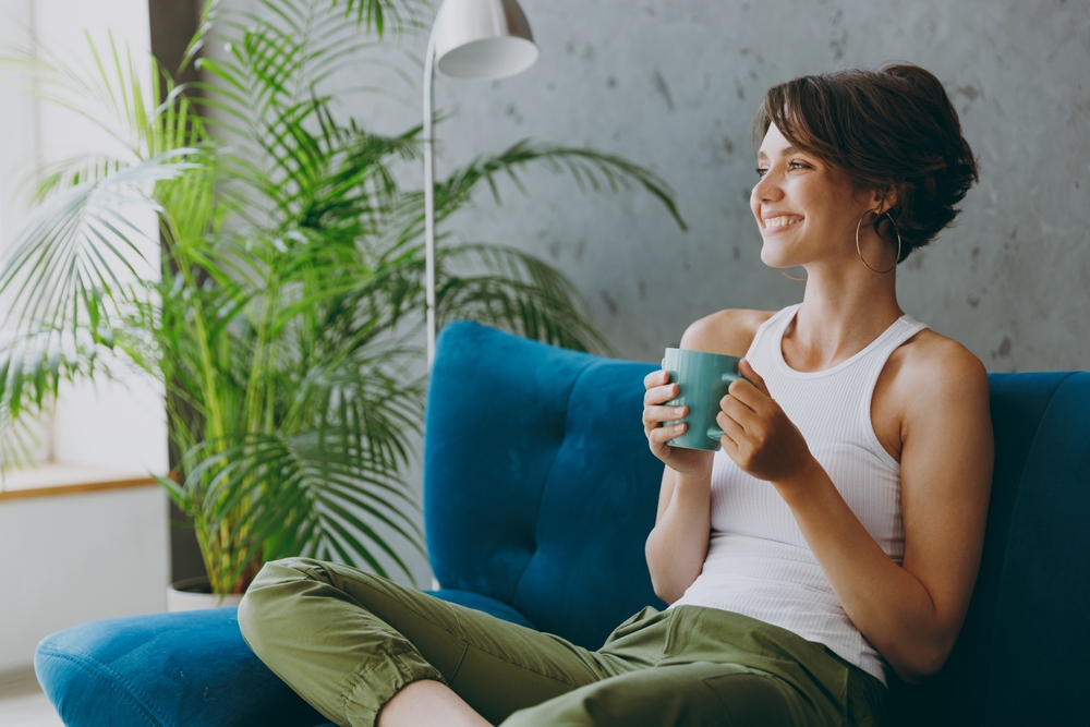 A woman drinking tea on her couch