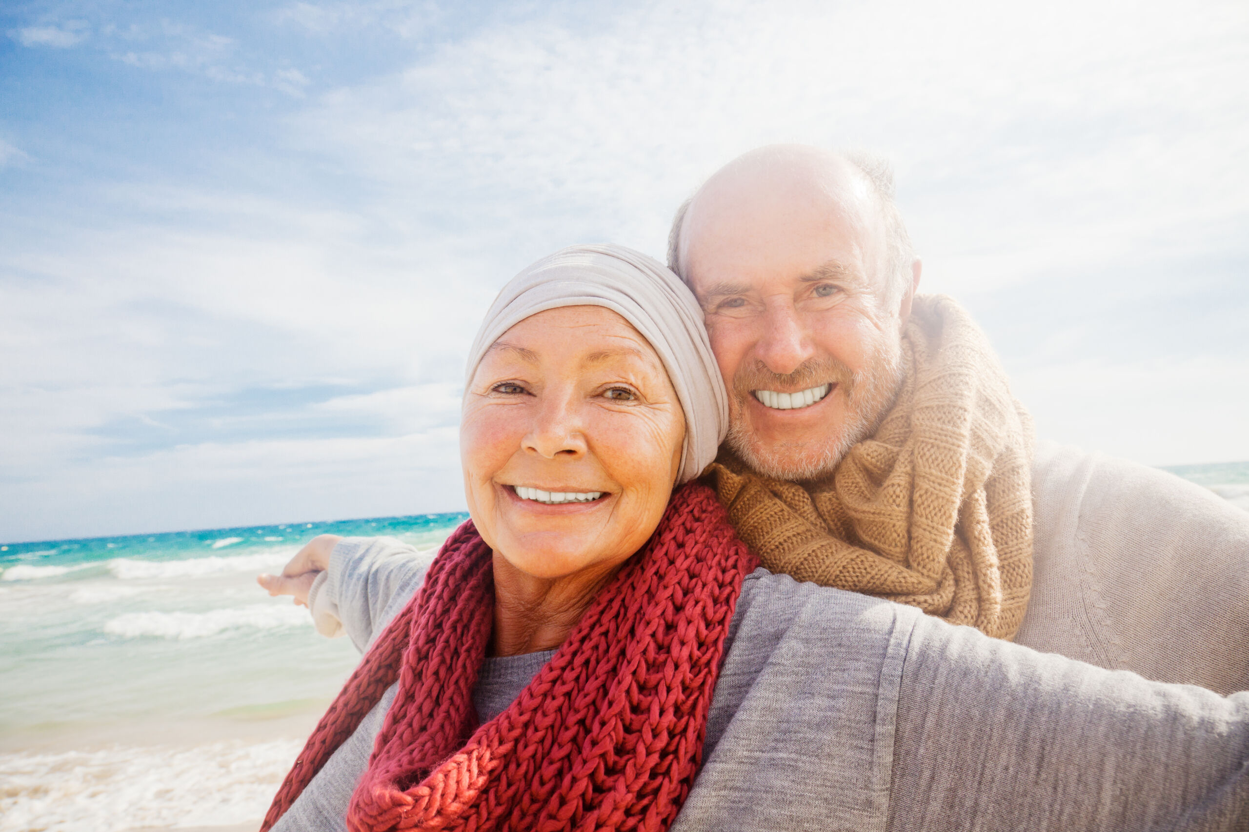 Older couple smiling on beach.